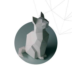 以下が含まれることがあります： 座っている白い幾何学的なペーパークラフトの猫。ターコイズ色の円が背景。猫は複数の三角形と多角形の形で構成されています。「SITTING CAT」の文字が下にあります。