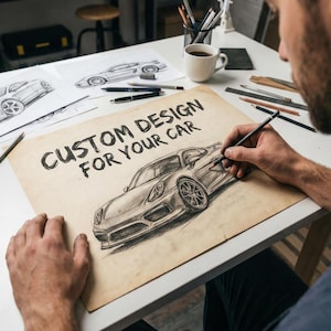 May include: A person sketching a car design on paper with the text "CUSTOM DESIGN FOR YOUR CAR". The drawing is in pencil and shows a detailed illustration of a sports car. Other car sketches and art supplies are on the table.