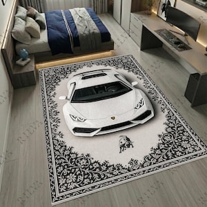 May include: A white Lamborghini Huracán car rug with a black and white floral border. The rug features the Lamborghini logo and is placed on a light grey wooden floor. The rug is rectangular.