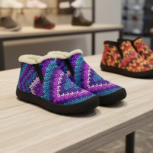 May include: A pair of winter boots with a quilted pattern in shades of purple, teal, and white. The boots have a black sole and a faux fur lining. Additional boots with a colorful pattern are visible in the background.