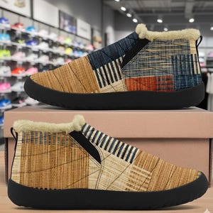 May include: Pair of slip-on shoes with a patchwork design in shades of brown, blue, and orange. The shoes have a black sole and a cream-colored, fuzzy trim around the ankle. The shoes are displayed on a light brown box.