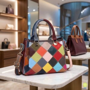 Puede incluir: Un bolso de mano multicolor con un diseño de patchwork en forma de rombos en tonos rojo, azul, amarillo, rosa y marrón. El bolso tiene dos asas superiores, herrajes de metal dorado y una correa de hombro desmontable con hebilla ajustable.
