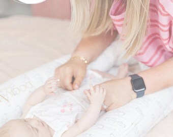 May include: A baby lies on a white patterned pillow, with a person's hands gently touching the baby. The text "4 Month Routine" is visible. The image also includes the text "The Mindful Sleep Coach".