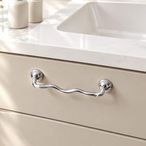 May include: A polished chrome drawer pull with a wavy, serpentine shape attached to a beige cabinet drawer. The metal handle features the engraved text Chris & Nicole on its surface, mounted with two circular bases on the flat front panel.