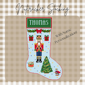 May include: A light blue Christmas stocking with a pixelated design featuring a nutcracker, Christmas tree, and gifts. The name "THOMAS" is displayed on a green banner. The text "Nutcracker Stocking" and "With Name Personalization!" are also present.