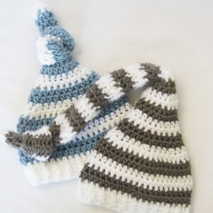 May include: Two crocheted hats with striped patterns. One hat is blue and white, the other is brown and white.