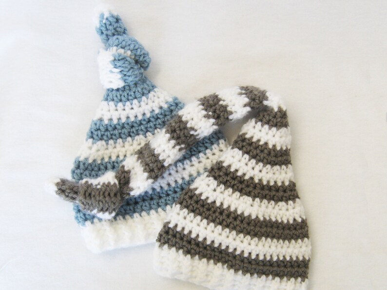 May include: Two crocheted hats with striped patterns. One hat is blue and white, the other is brown and white.
