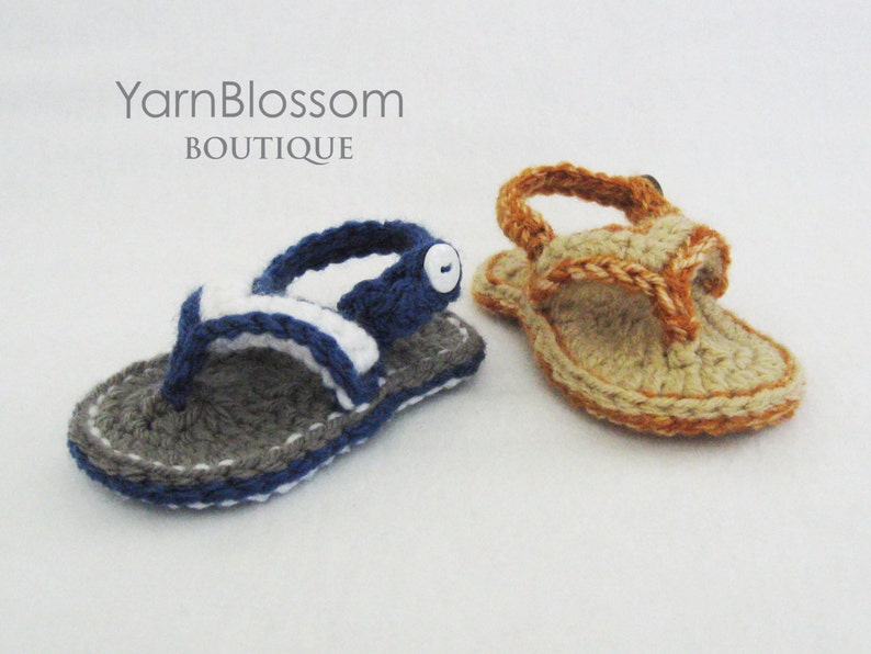 May include: Two pairs of crocheted sandals, one in gray and blue with a white stripe and a white button, and the other in tan and orange. The sandals are on a white background.