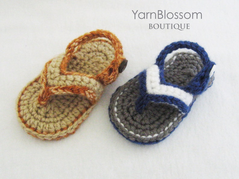 May include: Two pairs of crocheted sandals, one in beige with orange accents and one in gray with blue and white accents. Yarn Blossom Boutique.