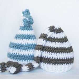 May include: Two crocheted hats with striped patterns. One hat is blue and white, the other is brown and white.