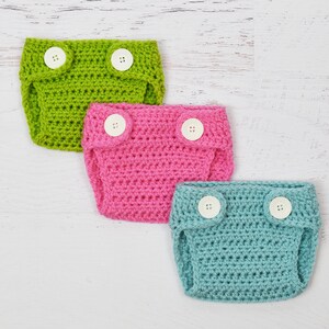May include: Three crocheted baby diaper covers in green, pink, and blue with white buttons.