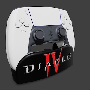 May include: A white and gray PlayStation 5 controller with a black base featuring the "Diablo IV" logo in red and white. The controller has a sleek design with buttons and joysticks.