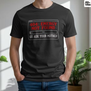 May include: Black t-shirt with the text "404: ENERGY NOT FOUND" in red, and "GO ASK YOUR MOTHER" in white. The shirt has a graphic resembling a computer error message. The shirt is a crew neck and is being worn.