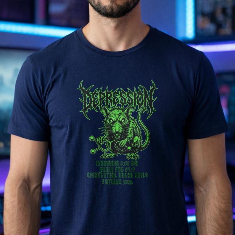 Puede incluir: Camiseta azul marino con un dise&ntilde;o gr&aacute;fico verde. El dise&ntilde;o presenta la palabra "DEPRESSION" en una fuente estilizada sobre una rata verde que sostiene una estructura molecular. Texto adicional debajo de la rata. Una camiseta azul oscuro.