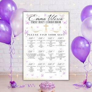 Op de afbeelding: Een zitplaatsindeling voor de Eerste Heilige Communie met de naam "Emma Vitoria" en de tekst "Please Find Your Seat". De kaart is versierd met vlinders en een kruis. Paarse en witte ballonnen en een kleine taart zijn ook aanwezig.