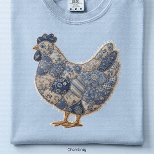 May include: A trio of cream-glazed ceramic mugs, each adorned with a hand-painted floral pattern in blue, green, and yellow hues. The mugs have a rounded form and a handle, perfect for enjoying a warm beverage. The speckled glaze adds a rustic touch.