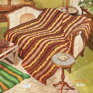 May include: A crocheted throw blanket with brown, orange and yellow stripes. The blanket is draped over a chaise lounge and a small table. The text "No. 4606 See Page 16" and "Vol. 36 50¢" is visible in the image.