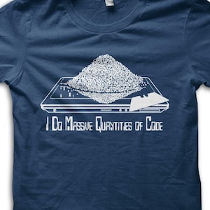 May include: Navy blue t-shirt with a white graphic of a laptop with a pile of code on top. The text "I Do Massive Quantities of Code" is printed below the graphic. The shirt is made of a soft material.