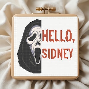 May include: A cross-stitch design in a wooden hoop features the Ghostface mask from the Scream horror film series. The text "HELLO, SIDNEY" is in red, dripping letters. The design is on a white background.
