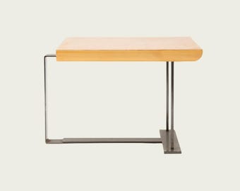 May include: A modern side table with a light wood top and a minimalist metal frame. The rectangular tabletop is approximately 24 inches long and supported by a sleek, angular metal base. The design is simple and contemporary.