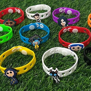 May include: A collection of colorful silicone bracelets with character charms. The bracelets are in various colors, including red, green, pink, yellow, blue, white, purple, orange, and black. Each bracelet features a different character design, perfect for fans of the animated movie.
