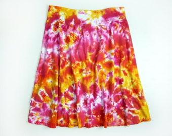 May include: A tie-dye skirt with a swirling pattern of pink, orange, and yellow.
