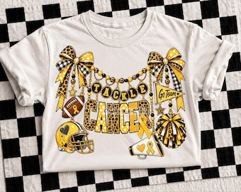 May include: A white t-shirt featuring a graphic design with the text TACKLE CANCER. The design includes yellow and black leopard print bows, a football, a helmet, a megaphone, a pennant flag reading GO TEAM, and pom-poms with yellow ribbons.