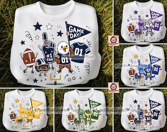 May include: A white sweatshirt featuring a graphic print of a cartoon eagle wearing a jersey, a football, a foam finger, and a pennant flag with the text GAME DAY. The design includes stars, confetti, and a goal post on a white fabric background.