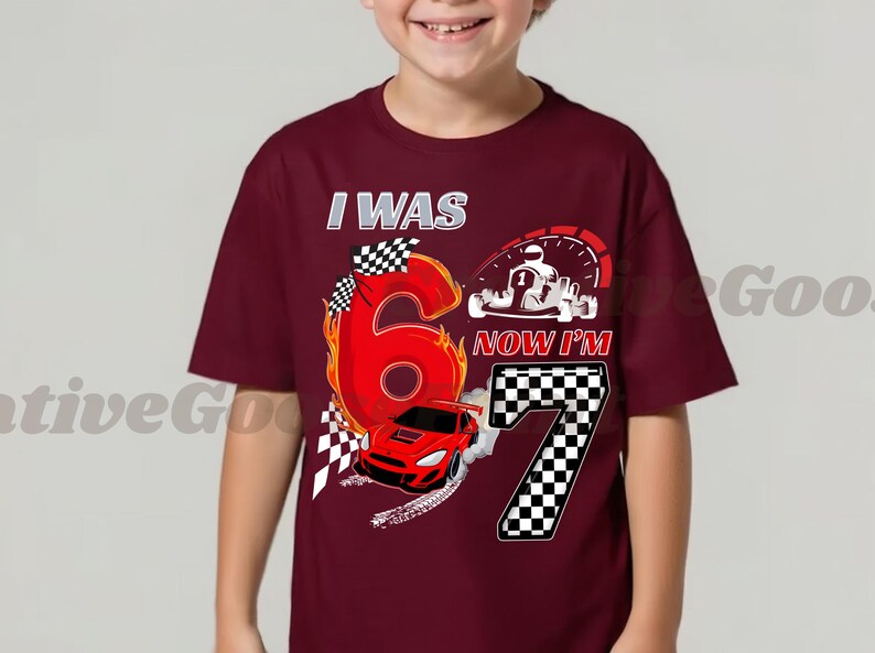 May include: A maroon t-shirt with a racing theme. The shirt features the text "I WAS 6 NOW I'M 7" with a large number 6 in red flames, a red race car, and a checkered flag design. A go-kart graphic is also present.