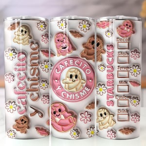 May include: A white tumbler with a design featuring the words "Cafecito y Chisme" and "Starbucks". The design includes cartoon characters, flowers, and coffee-related elements in pink, brown, and beige.