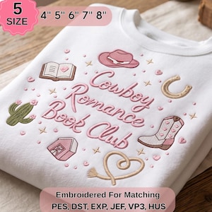 May include: A white sweatshirt featuring pink and tan embroidery with the text Cowboy Romance Book Club. The design includes a pink hat, an open book, a cactus, a horseshoe, a barn, a boot, and a rope heart. Available in 5 sizes: 4", 5", 6", 7", 8".