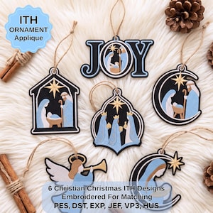 May include: Six embroidered Christmas ornaments featuring nativity scenes, the word JOY, and an angel with a trumpet. Each ornament has a black background with light blue and gold accents, a hanging twine loop, and intricate stitched details.