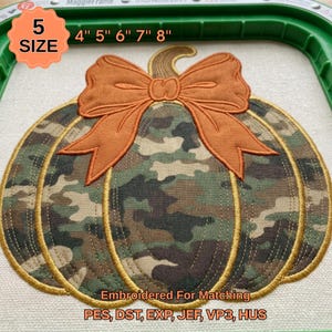 Peut inclure: Un motif de broderie représentant une citrouille avec un motif camouflage et un grand nœud orange sur le dessus. Le texte 5 SIZE 4" 5" 6" 7" 8" et Embroidered For Matching PES, DST, EXP, JEF, VP3, HUS est visible sur le tissu écru dans un cadre vert.