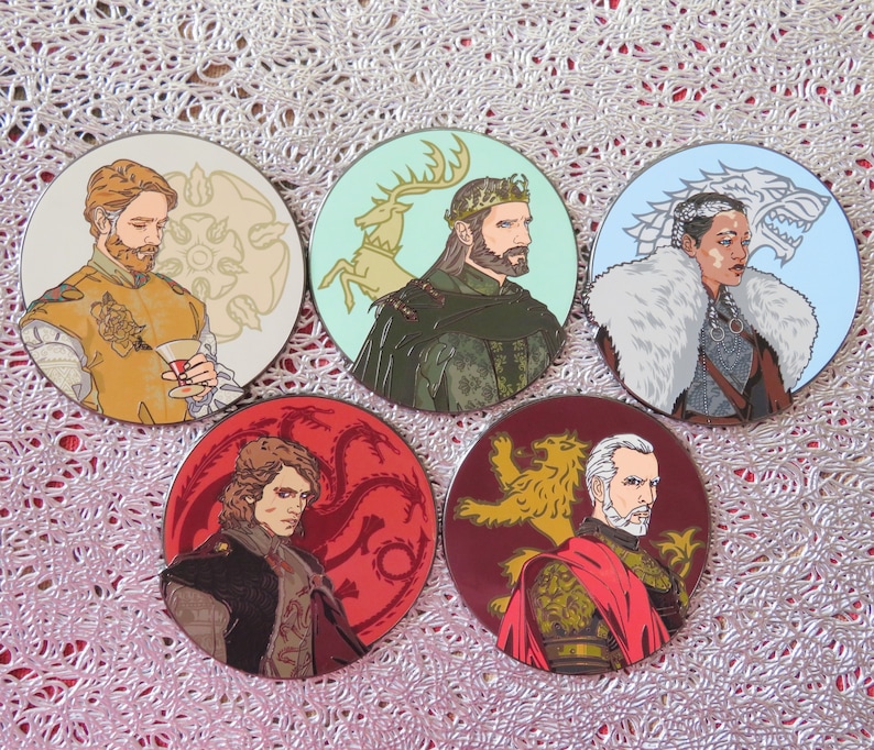 Puede incluir: Cinco pines redondos de esmalte de colores con personajes del popular programa de televisi&oacute;n Game of Thrones. Cada pin presenta un personaje diferente con el emblema de su casa. Los pines son perfectos para los fan&aacute;ticos del programa y son un gran regalo.