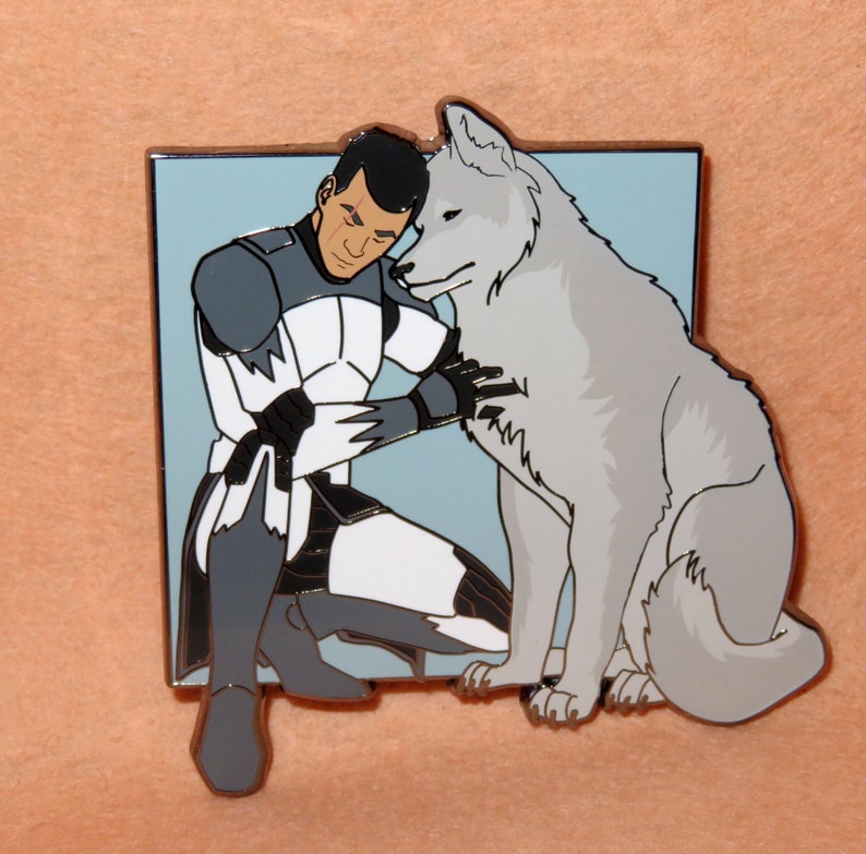 May include: A white and gray enamel pin featuring a cartoon character in a white and gray uniform hugging a white wolf. The character has dark hair and a serious expression.