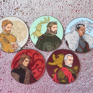 Puede incluir: Conjunto de cinco pines redondos con personajes del popular programa de televisi&oacute;n Game of Thrones. Cada pin presenta un personaje diferente con el emblema de su casa. Los pines est&aacute;n hechos de metal y tienen un acabado brillante.