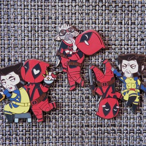 Può includere: Cinque spille in smalto con personaggi della serie di fumetti Marvel Deadpool. Le spille sono rosse, nere, gialle e bianche. I personaggi includono Deadpool, Wolverine e Cable.
