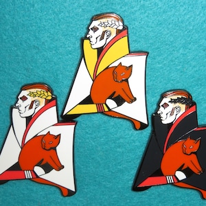 May include: Three enamel pins featuring a stylized portrait of a person with a cat. The pins are in three color schemes: yellow, white, and black.