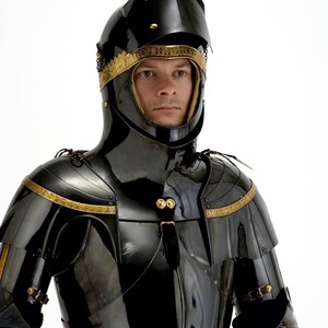 May include: A black, polished suit of armor with gold trim. The helmet has a pointed top and a visor. The armor covers the shoulders, chest, and neck. The gold trim is around the helmet and on the shoulders. The armor is highly reflective.