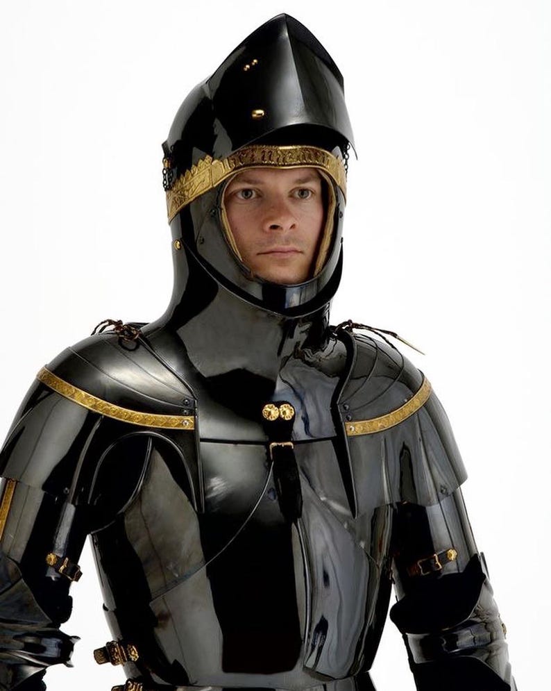 May include: A black, polished suit of armor with gold trim. The helmet has a pointed top and a visor. The armor covers the shoulders, chest, and neck. The gold trim is around the helmet and on the shoulders. The armor is highly reflective.