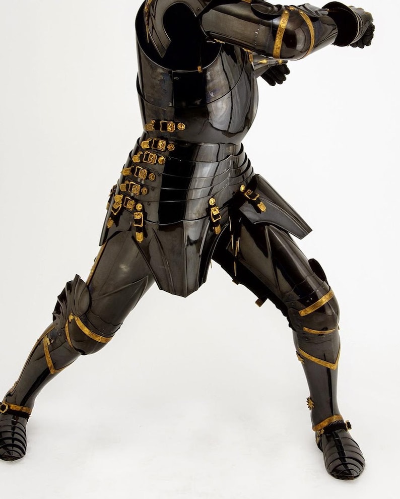 May include: A black suit of armor with gold accents. The armor is highly polished and reflects light. The design includes articulated plates, buckles, and decorative trim. The image shows the armor from the chest down, with the legs in a dynamic pose.