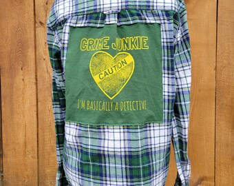 Camisa de franela reciclada con estampado de crímenes reales – Espalda con gráfico “Crime Junkie” – Camisa a cuadros verdes con botones