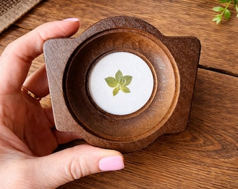 Una miniatura da appendere al muro, raffigurante una vera foglia pressata in una cornice di legno di 5x5 cm: un'opera d'arte botanica naturale.
