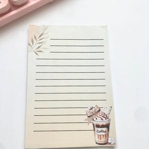 Peut inclure: Une tasse en céramique blanche avec une anse noire et le texte "But First, Coffee" en noir, en gras. La tasse est posée sur une surface blanche. La tasse mesure environ 10 cm de haut.