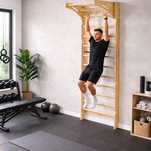 May include: A wooden wall-mounted Swedish ladder with horizontal rungs. A person is hanging from the top rung. The gym setting includes a black exercise mat, weights, and a bench. The ladder is approximately 8 feet tall.