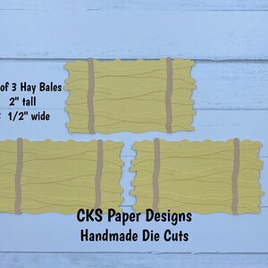 May include: Set of three yellow paper hay bale die cuts, each measuring 2 inches tall and 3 1/2 inches wide. The die cuts are handmade and feature a realistic hay bale texture. The text "CKS Paper Designs Handmade Die Cuts" is printed below the hay bales.