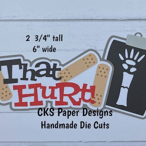 May include: Handmade die cuts featuring the words "That Hurt!" in red and black letters with two brown bandages. The die cuts are 2 3/4 inches tall and 6 inches wide. A black and white X-ray image of a broken bone is also included. The X-ray is 3 1/2 inches tall and 2 7/8 inches wide.
