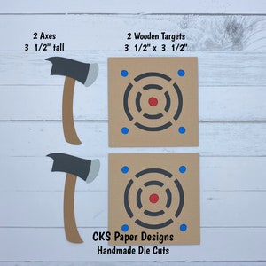 May include: Two wooden axe targets with bullseye designs and two wooden axes. The targets are 3 1/2 inches by 3 1/2 inches and the axes are 3 1/2 inches tall. The targets are brown with black bullseye designs and blue dots. The axes are brown with black blades and gray handles. The text "CKS Paper Designs Handmade Die Cuts" is at the bottom of the image.