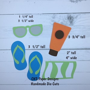 May include: A set of die-cut paper shapes for crafting, including a pair of flip-flops, a tube of sunscreen, sunglasses, and a beach towel. The shapes are all green, blue, and orange. The text on the image reads "1 1/4" tall, 3 1/2" wide, 3 1/2" tall, 3 3/4" tall, 2" tall, 4" wide, CKS Paper Designs, Handmade Die Cuts".