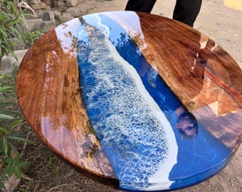 Tavolino da caffè ovale su misura con motivo a onda oceanica, in legno con bordo naturale e rivestimento in resina blu.